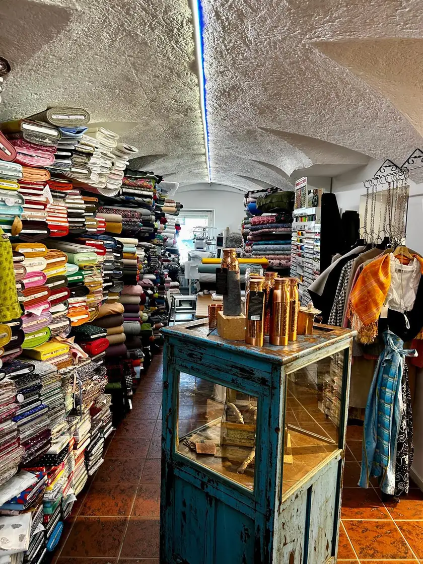 Stoffregale bis unter das Gewölbe im Laden